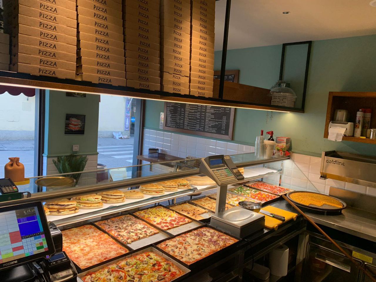 Il bancone della pizzeria con le teglie